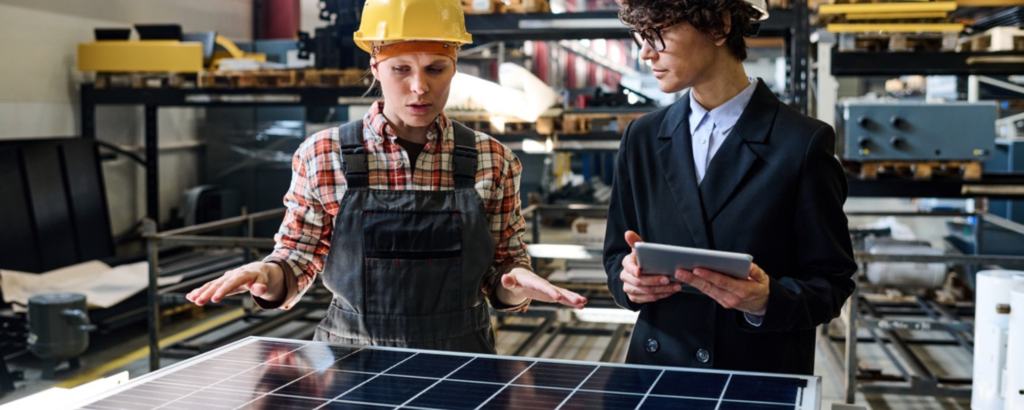 Zwei Fachleute stehen vor einem Solarpanel und planen.