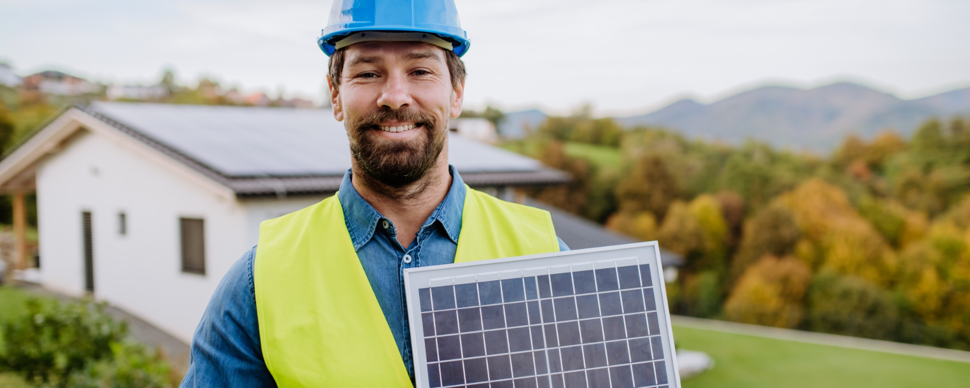 Dekoratives Bild: Mann mit einzelnem Solarpanel in Baukleidung ist bereit zum Einbau eines Solarspeichers.